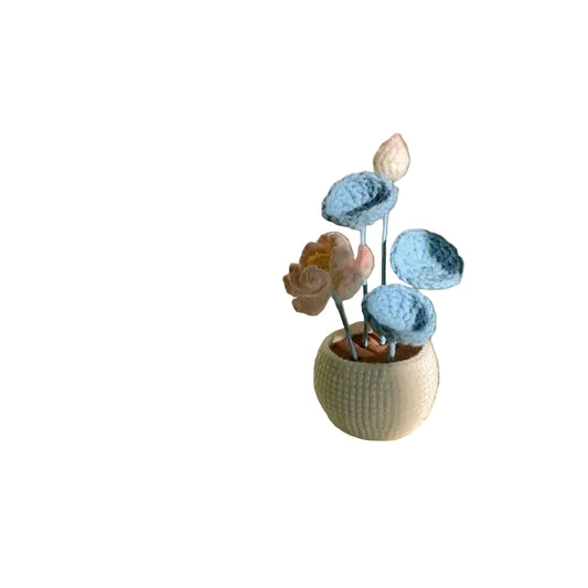 Knitted flower bouquet in a pot on a textured surface with soft lighting