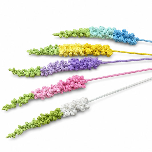 Five crocheted lavender sprigs in pastel colors arranged diagonally on a white background, including green, yellow, purple, pink, and white.