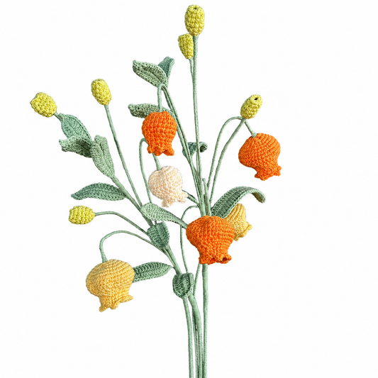 Crocheted flowers in orange, yellow, and green on a white background