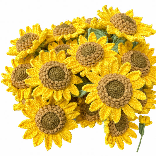 A cluster of crocheted sunflowers with bright yellow petals and brown centers, shown against a plain white background.