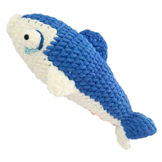 Blue and white fish-shaped crochet toy held by a hand against a neutral background
