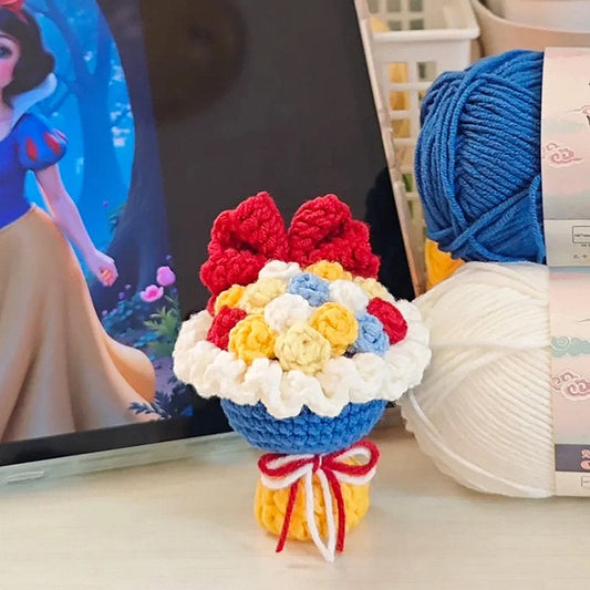 Colorful knitted flower bouquet in front of a laptop displaying an animated character.
