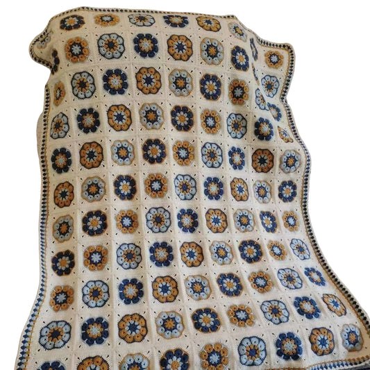 Colorful crocheted blanket with a geometric pattern on a couch.