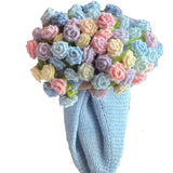 Person holding a colorful bouquet of crocheted flowers against a blurred background