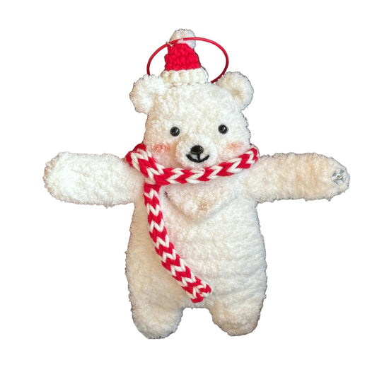 White teddy bear with a red and white striped scarf held by a person.