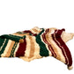 Bed with striped bedding, colorful blanket, and various pillows including a dog pillow.