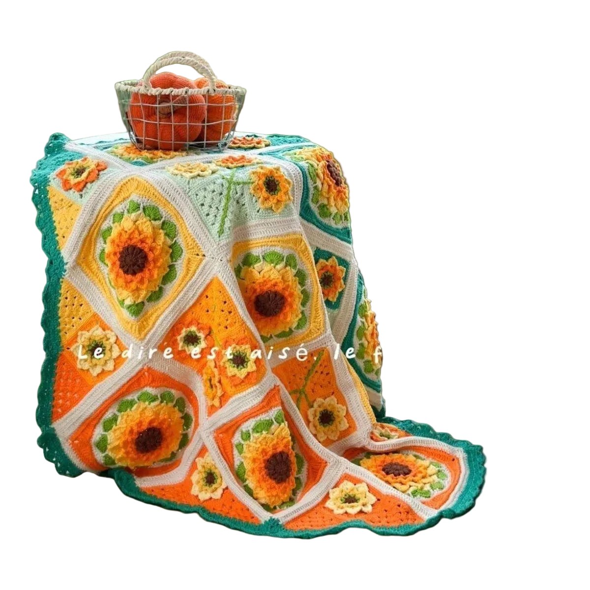 Crocheted blanket with sunflower pattern on a green surface