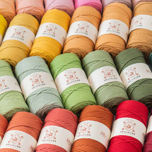 Assorted colorful yarn skeins with labels on a white background