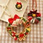 Decorative Christmas wreath ornament with a bell and bow on a checkered fabric background