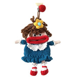 Crocheted doll with brown hair, red scarf, blue dress, and white collar on a white background