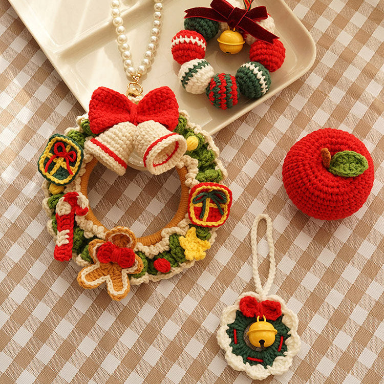 Decorative Christmas ornaments including a wreath, candy cane, and apple on a checkered tablecloth.