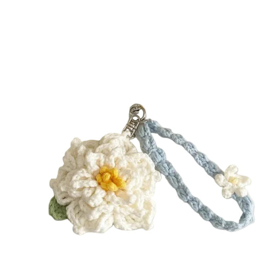 Colorful yarn balls with a crocheted keychain on a light background