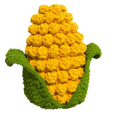 Knitted corn on the cob toy held in front of a neutral background