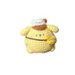 Hand holding a small yellow plush toy with a white hat against a neutral background