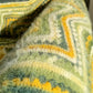 Close-up of a textured fabric with green and yellow patterns