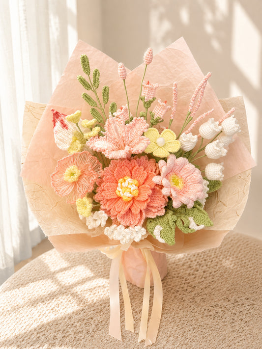 A handmade crochet flower bouquet wrapped in light peach tissue paper and tied with a cream ribbon, displayed on a textured beige surface with soft window light casting shadows.