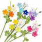 A set of crocheted artificial flowers with green leaves and stems, shown in multiple colors including orange, yellow, blue, purple, pink, and white on a plain white background.