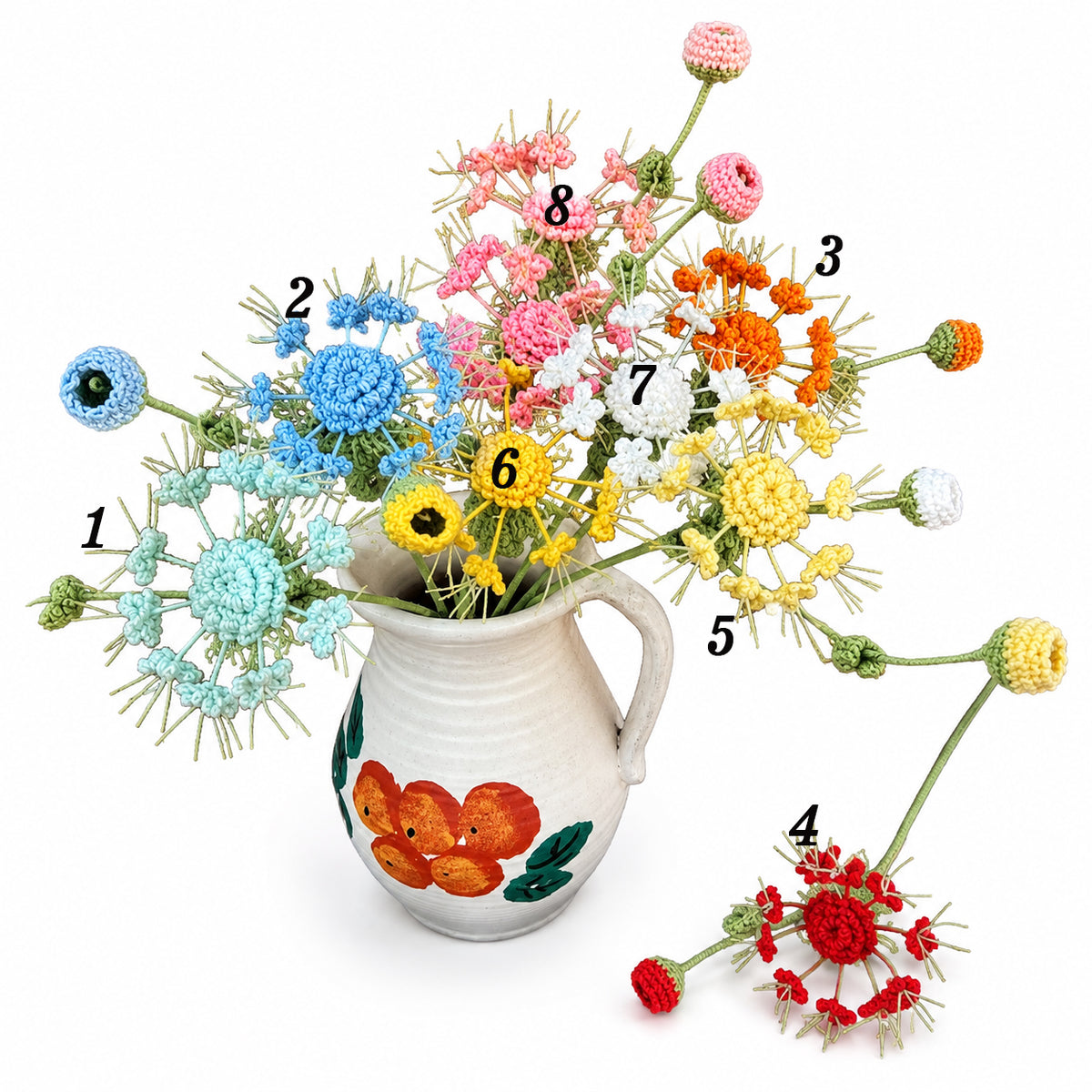 A set of eight different crocheted flower bouquets in various colors (blue, pink, orange, yellow, red, white, and light blue) arranged in a white ceramic pitcher with orange and green floral designs. The image has black numbered labels (1 through 8) pointing to each individual bouquet on a clean white background.