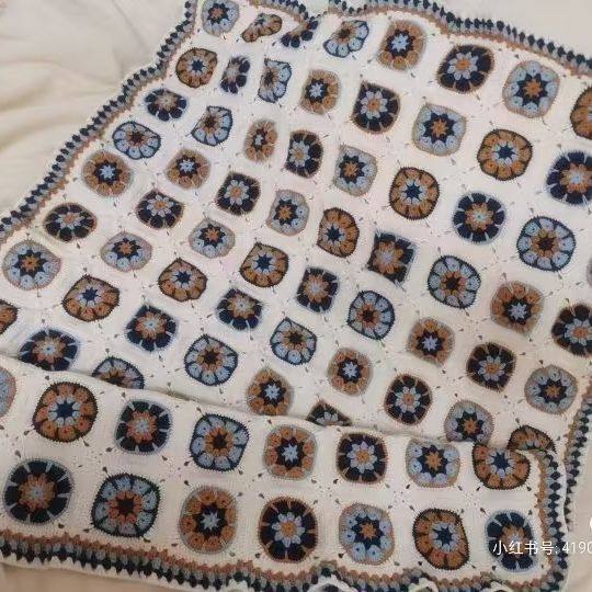 Crocheted blanket with a geometric pattern on a white background