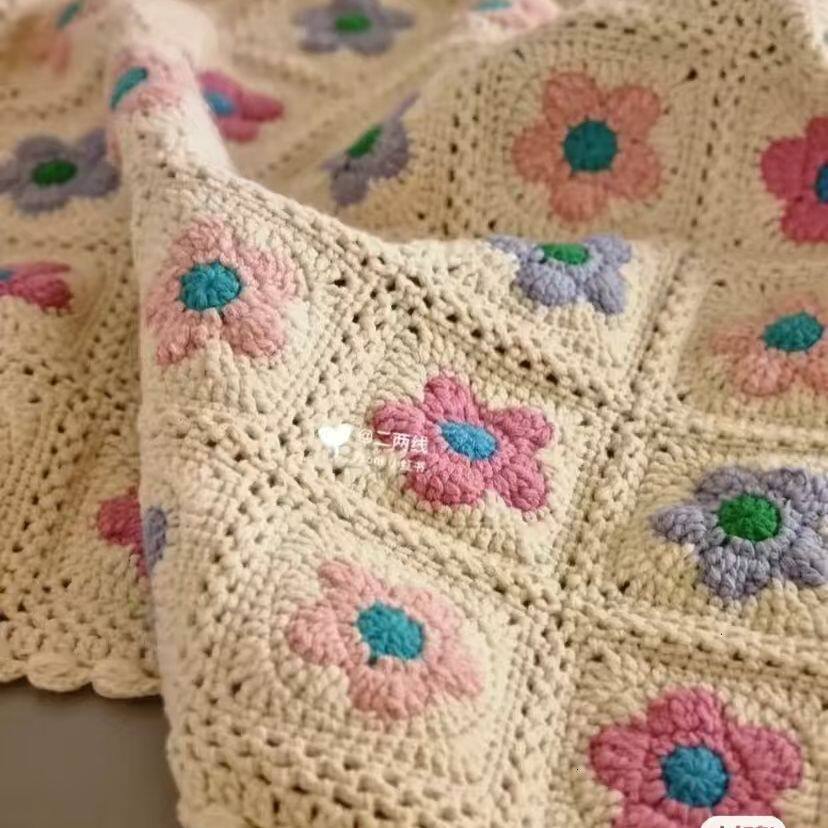 Close-up of a crocheted blanket with floral patterns.