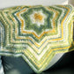Knitted blanket with a geometric pattern draped over a chair.