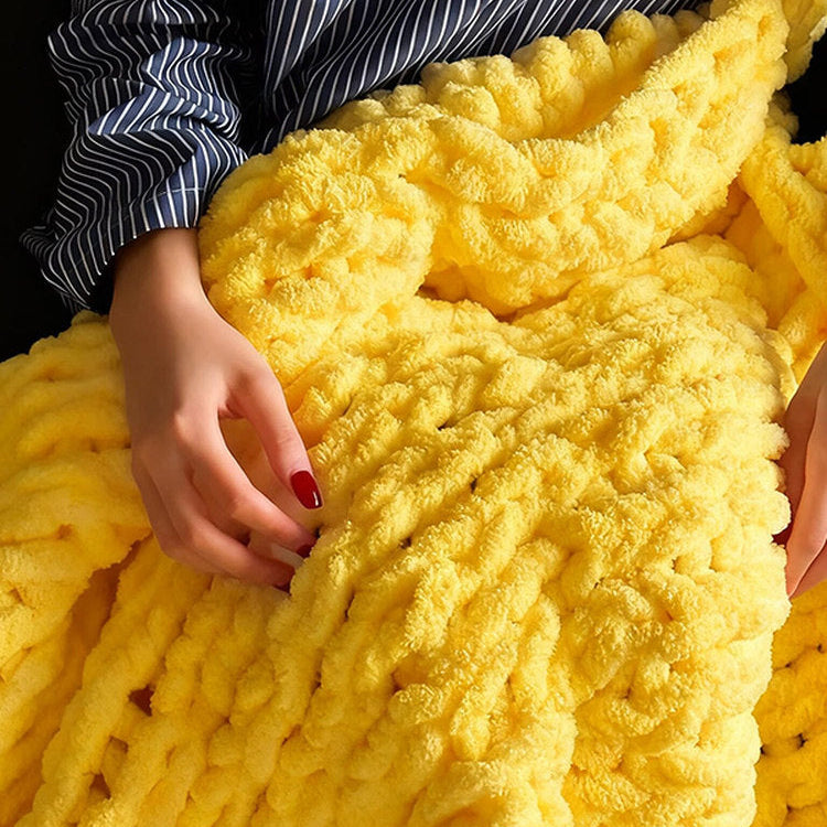 Yellow textured blanket with a person's hand on it