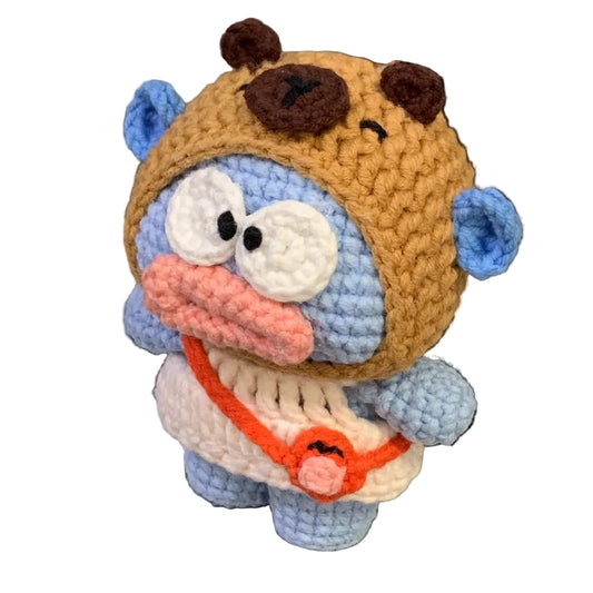 Crocheted animal plush toy with a helmet on a laptop keyboard