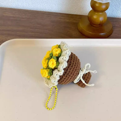 Crocheted flower pot with yellow flowers on a white surface