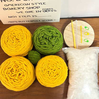 Yellow and green textured items on a wooden surface with a sign in the background.