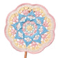 Colorful crocheted mandala on a stand with a blurred outdoor background