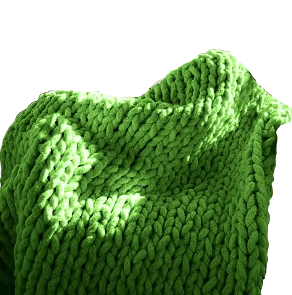 Person sitting on a couch with a green chunky knit blanket draped over them