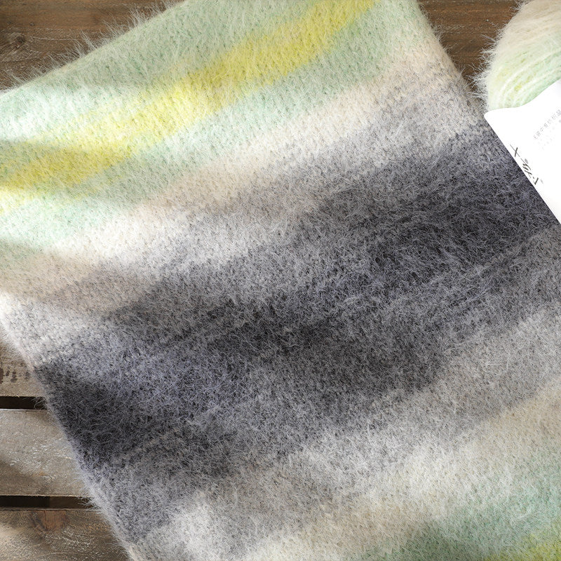 Textured fabric swatch with gradient colors on a wooden surface